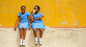 Ghana kinderdorp Tema twee vriendinnen lachend bij hun school
